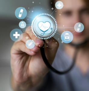 A conceptual image of a healthcare professional's hand holding a stethoscope with an augmented digital interface showing a heart icon and various medical symbols representing the convergence of technology and healthcare